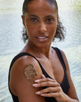 Woman applying body scrub to her shoulder.