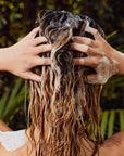 Woman washing her hair with shampoo.