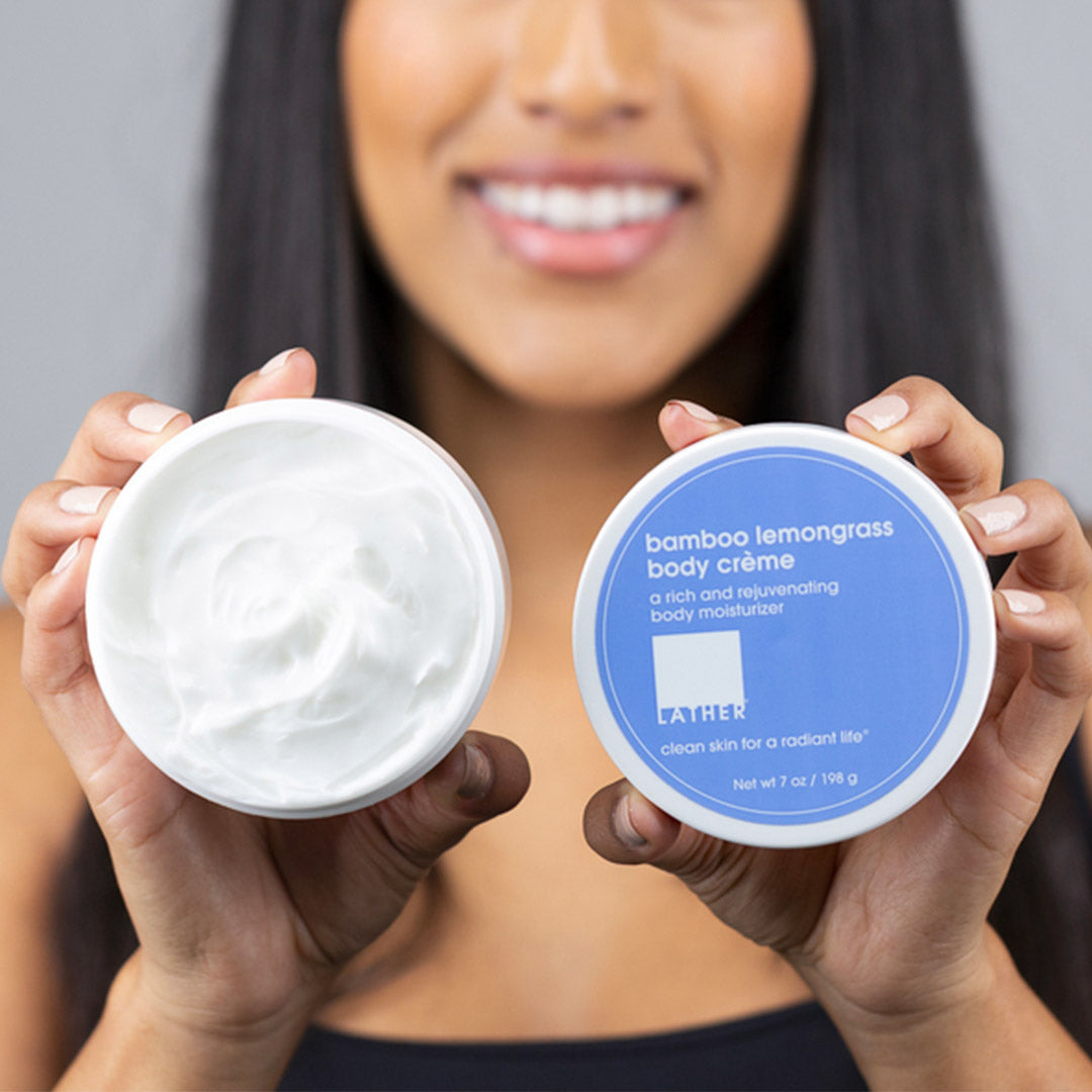 women holding open Bamboo Lemongrass Body Crème jar to show texture